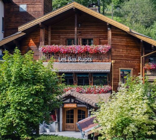 Flowered façade of Les Bas Rupts hotel in Gérardmer, traditional Vosges architecture.