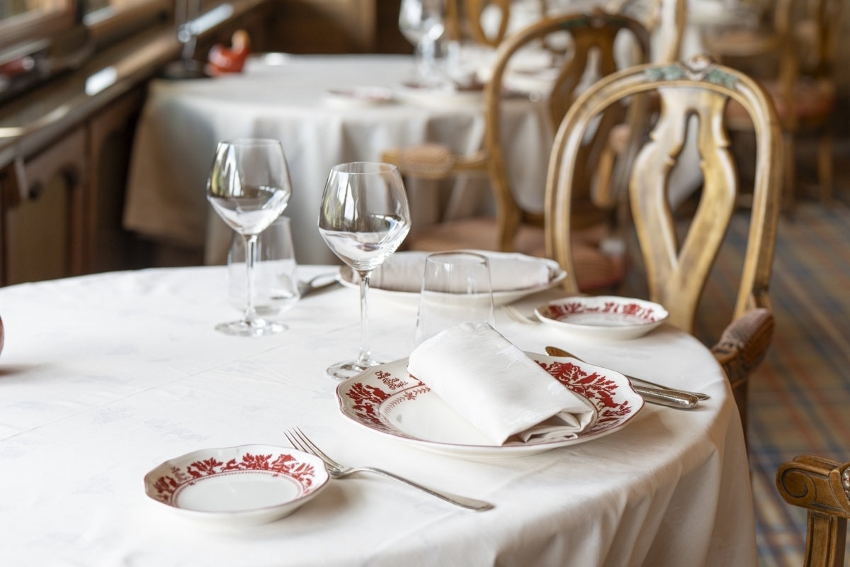 Set table on the flowered terrace of Les Bas Rupts restaurant with forest view
