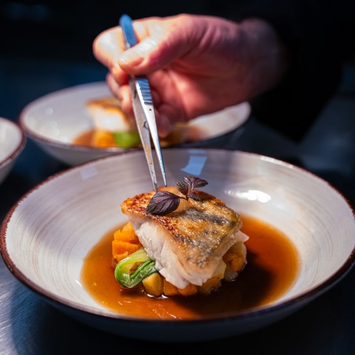 Dressage d’un plat gastronomique à base de poisson au restaurant Les Bas Rupts à Gérardmer.