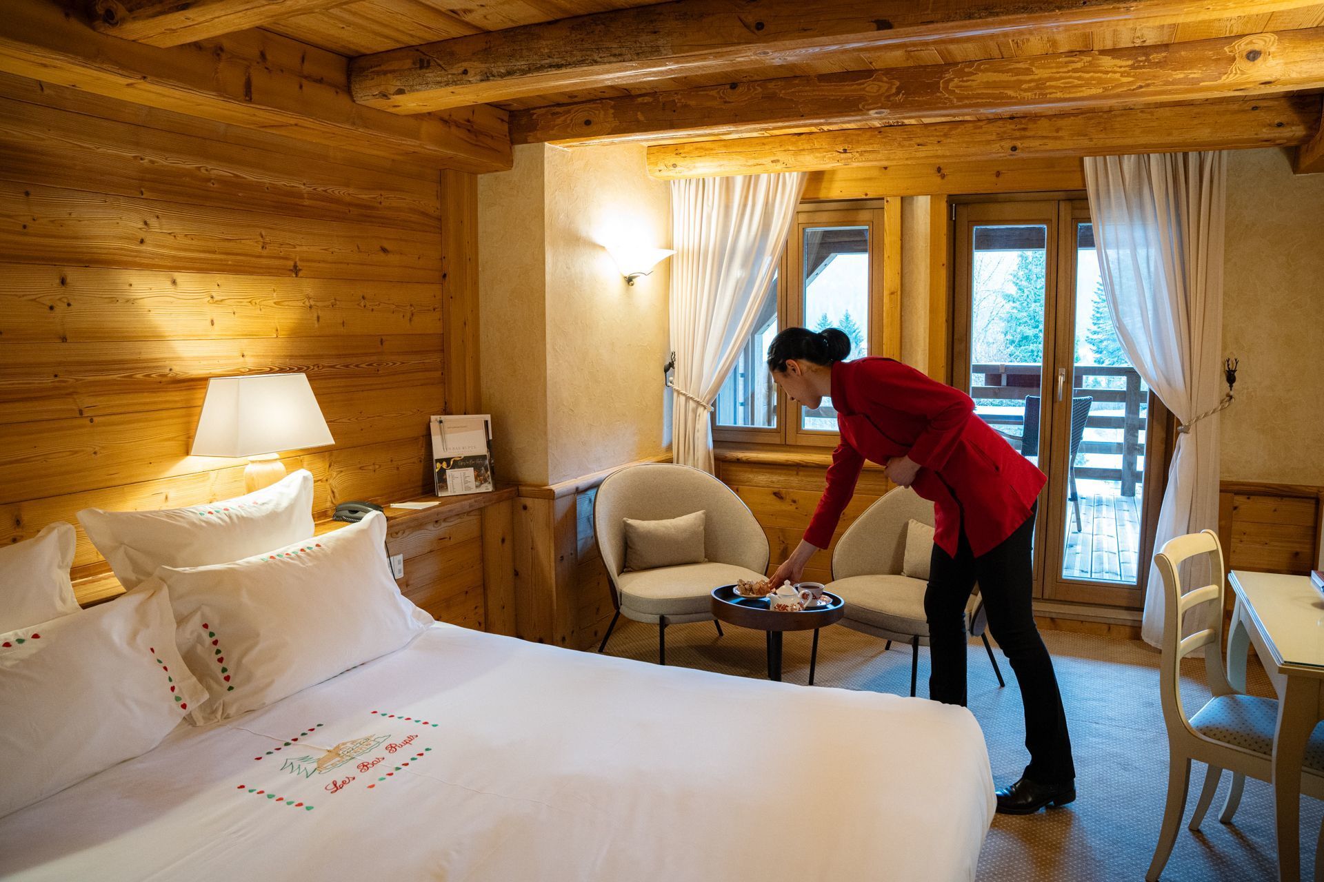 Chambre Charme de l’hôtel Les Bas Rupts, style chalet chaleureux avec terrasse privative, vue montagne et piscine extérieure