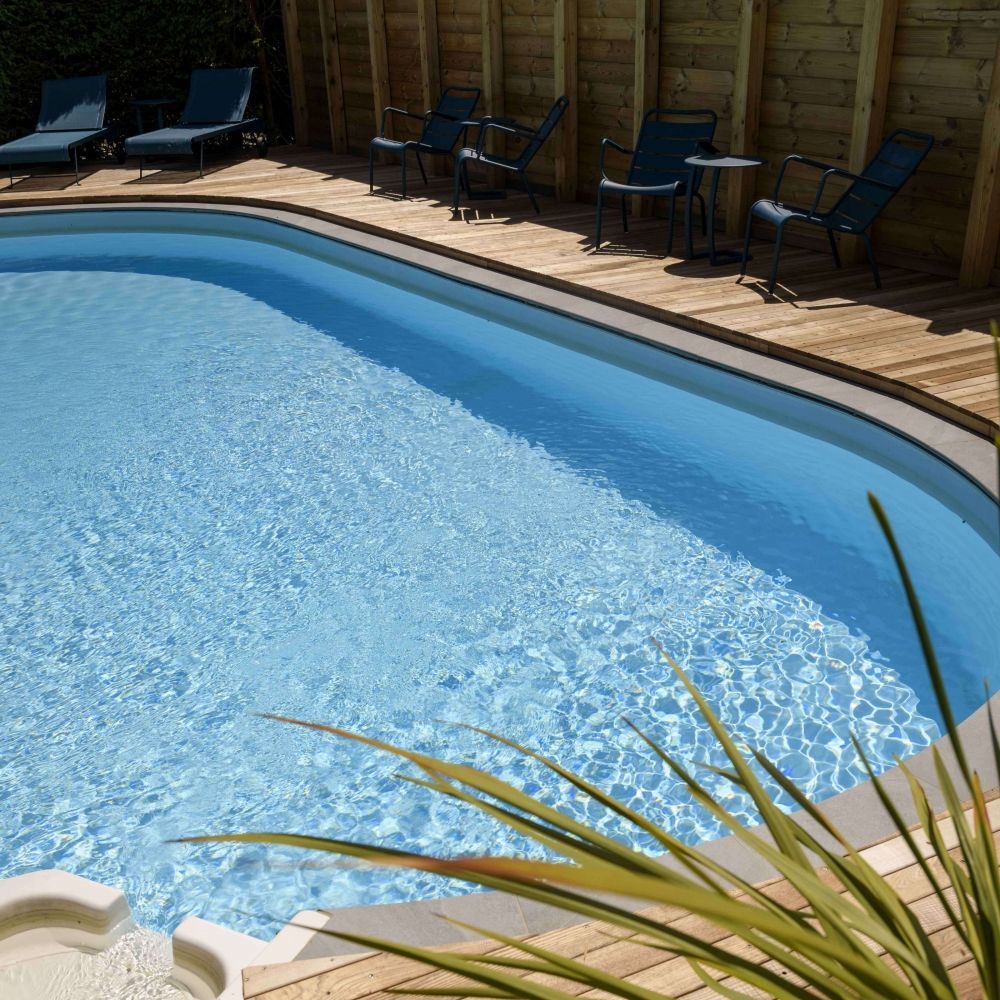 Sunlit outdoor pool at Les Bas Rupts hotel, wellness area with wooden deck and loungers