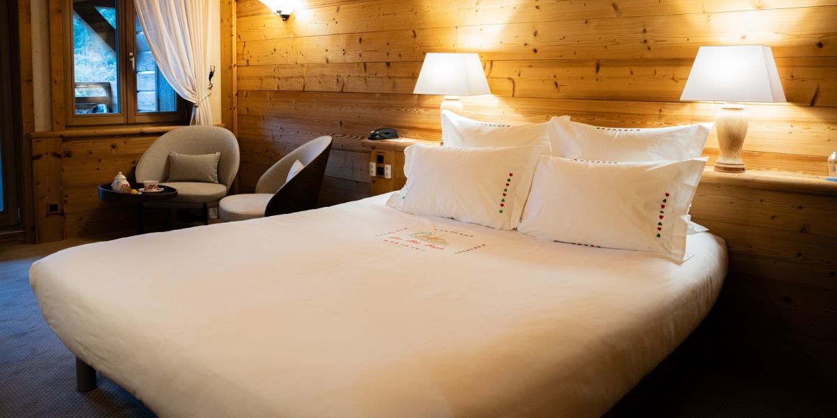 Charme room at Hotel Les Bas Rupts, warm chalet-style with private terrace, mountain view and outdoor pool