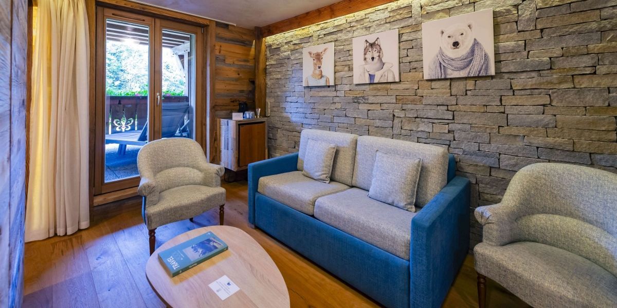 Junior Suite at Les Bas Rupts hotel featuring a bedroom, separate living area, modern bathroom, and a terrace with forest views.