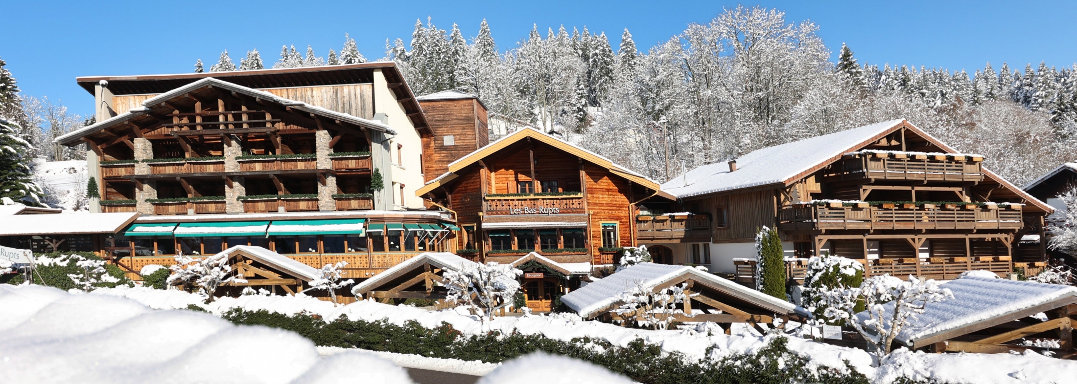 Flowered wooden balcony of Les Bas Rupts hotel in G&eacute;rardmer, reflecting the chalet spirit and elegant mountain style