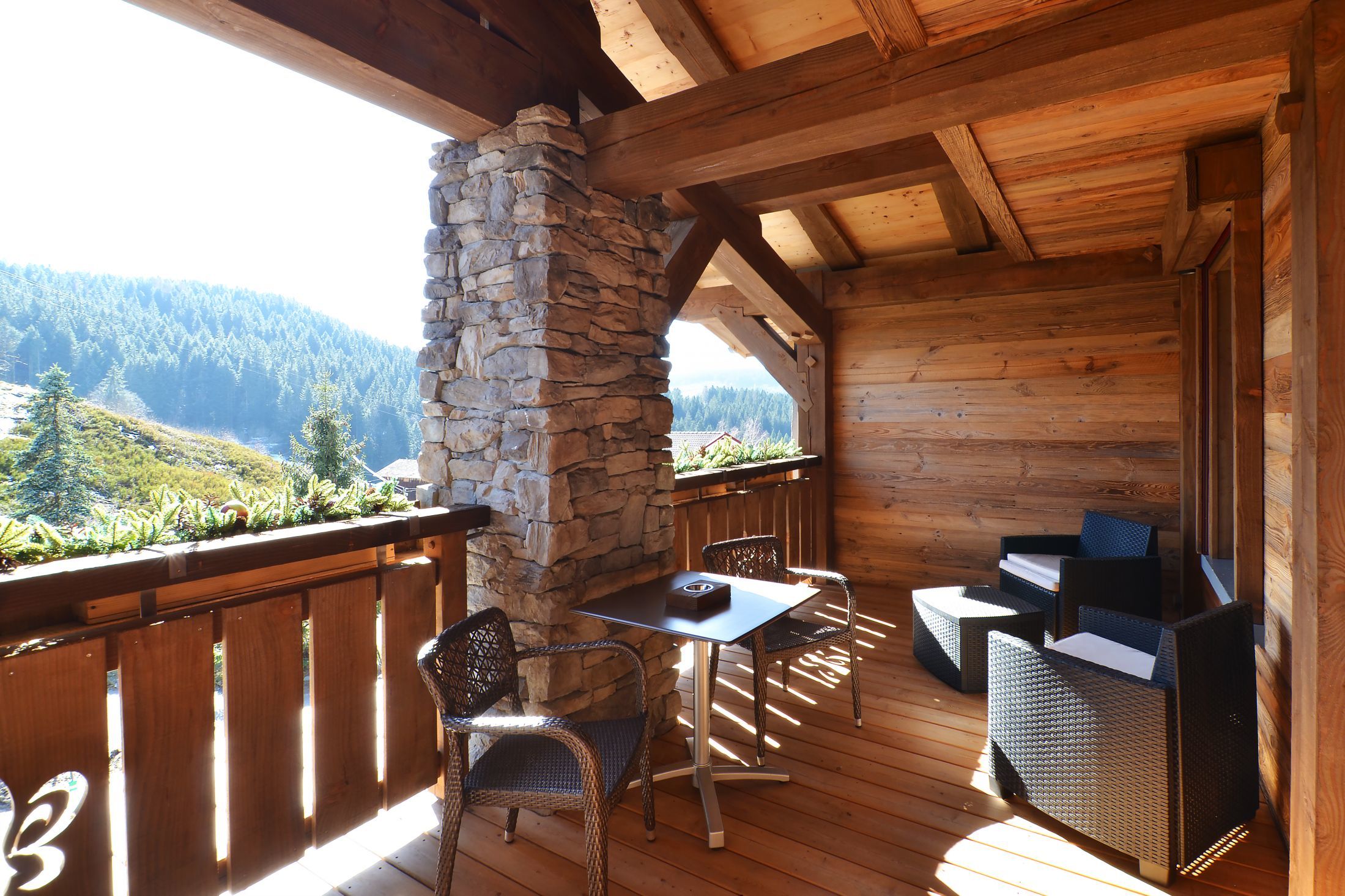 Suite Junior de l’hôtel Les Bas Rupts avec chambre, salon séparé, salle de bains moderne et terrasse offrant une vue sur la nature.
