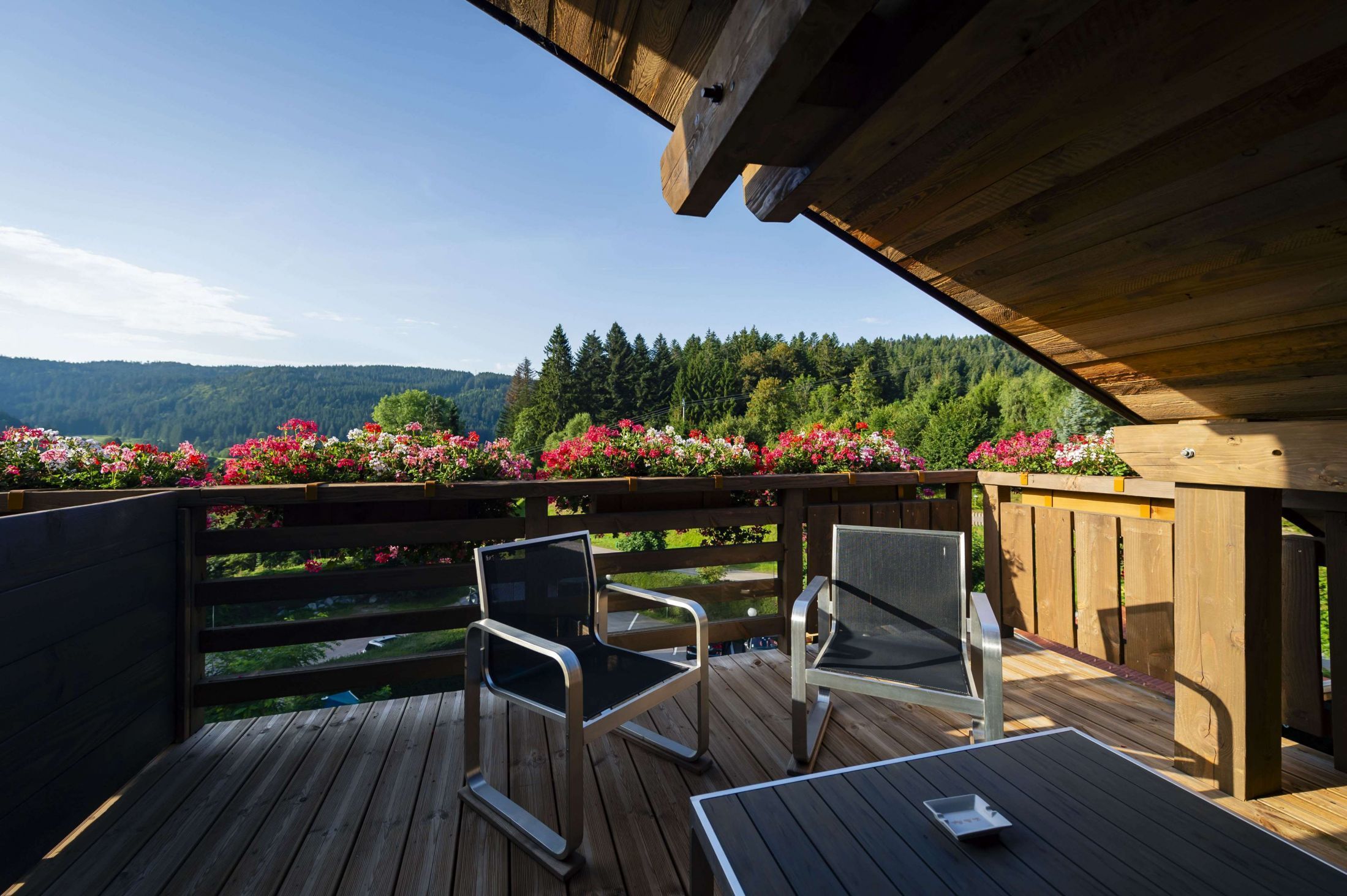 Chambre Confort de l’hôtel Les Bas Rupts, ambiance cosy avec terrasse privative offrant une vue sur la montagne et la forêt