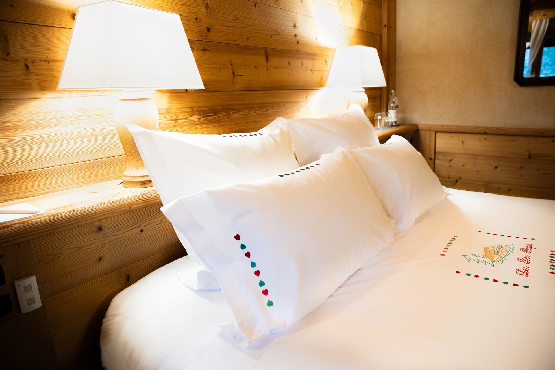 Chambre Charme de l’hôtel Les Bas Rupts, style chalet chaleureux avec terrasse privative, vue montagne et piscine extérieure
