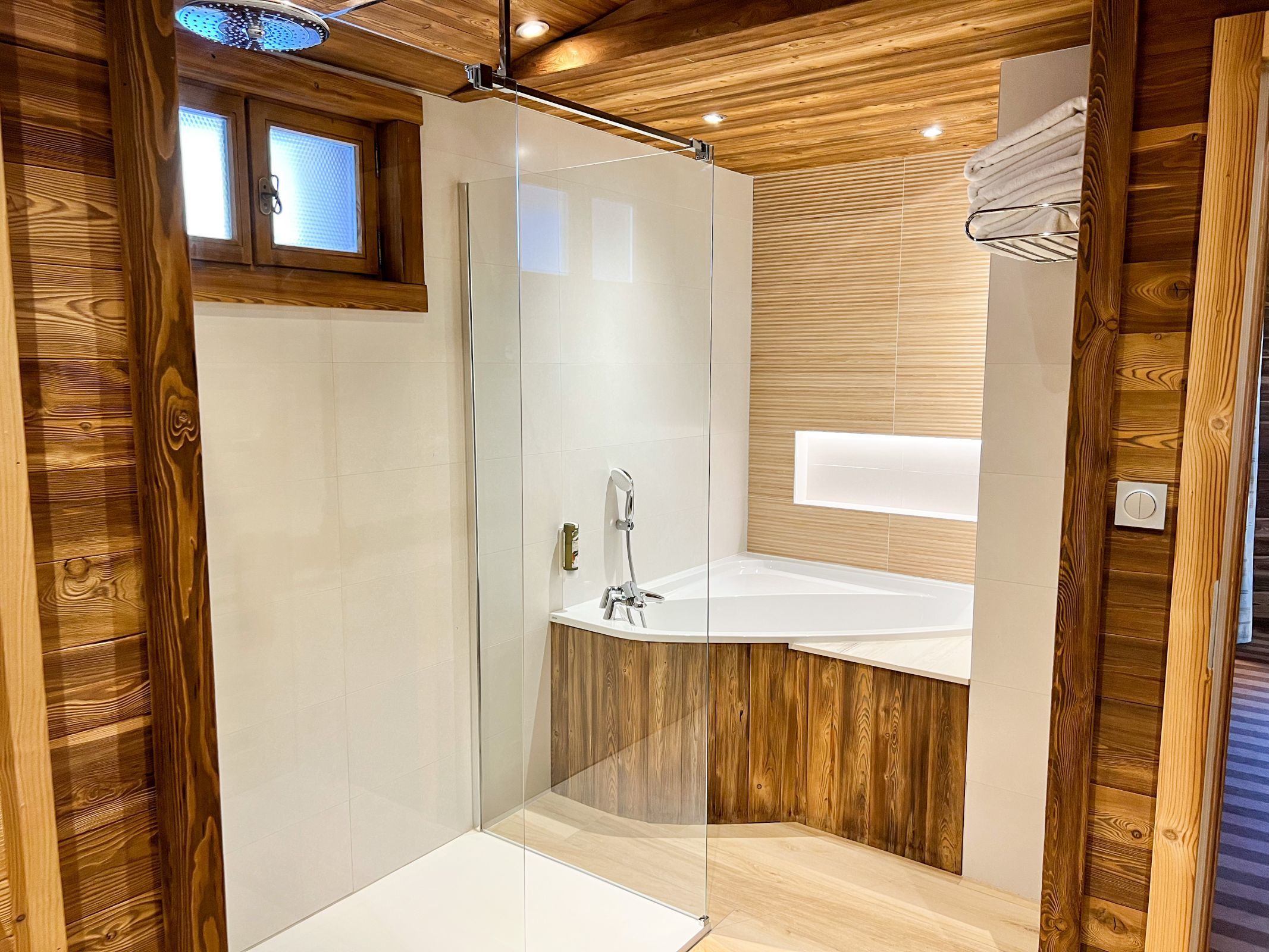 Suite Junior de l’hôtel Les Bas Rupts avec chambre, salon séparé, salle de bains moderne et terrasse offrant une vue sur la nature.