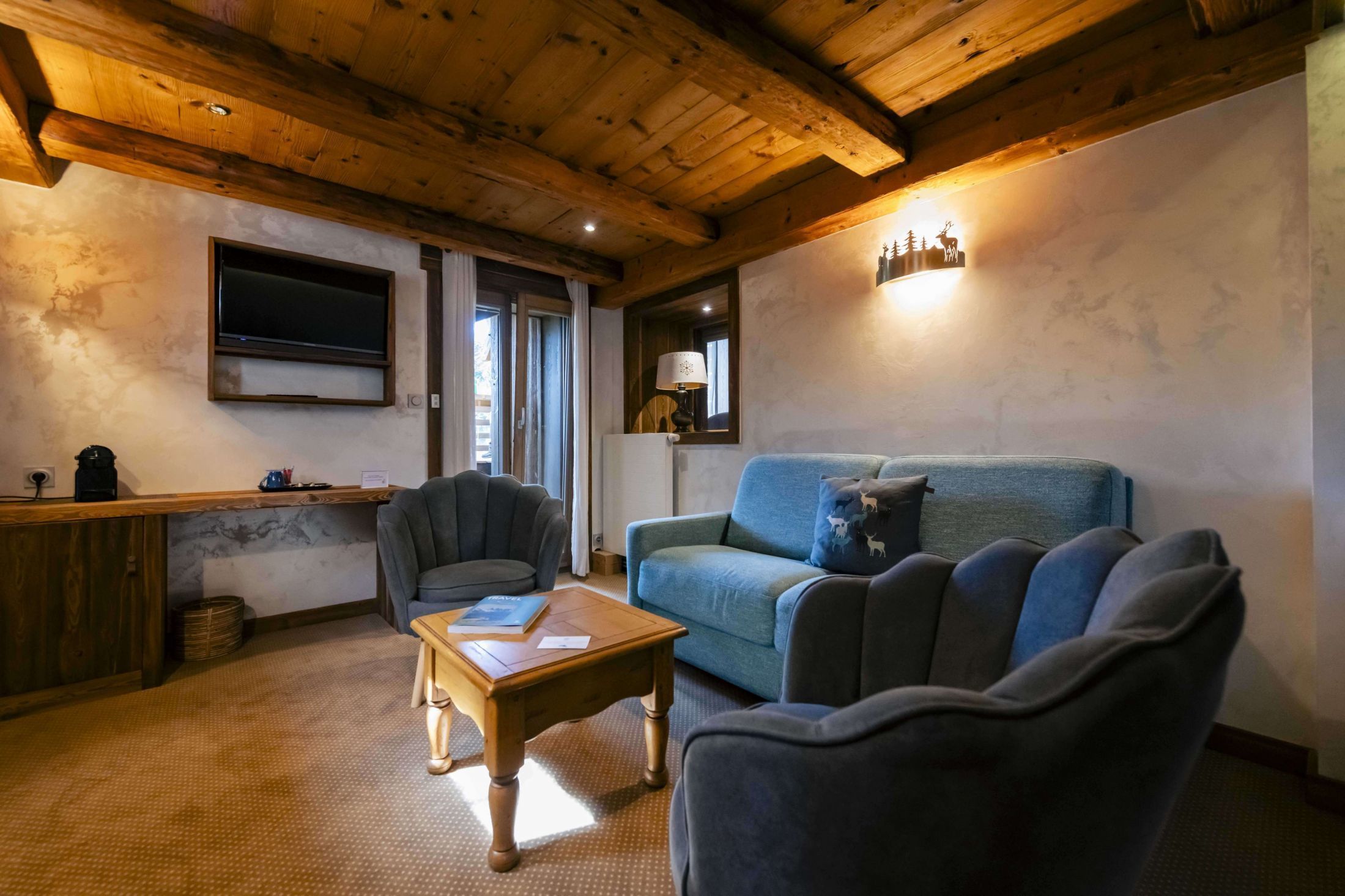 Suite Junior de l’hôtel Les Bas Rupts avec chambre, salon séparé, salle de bains moderne et terrasse offrant une vue sur la nature.