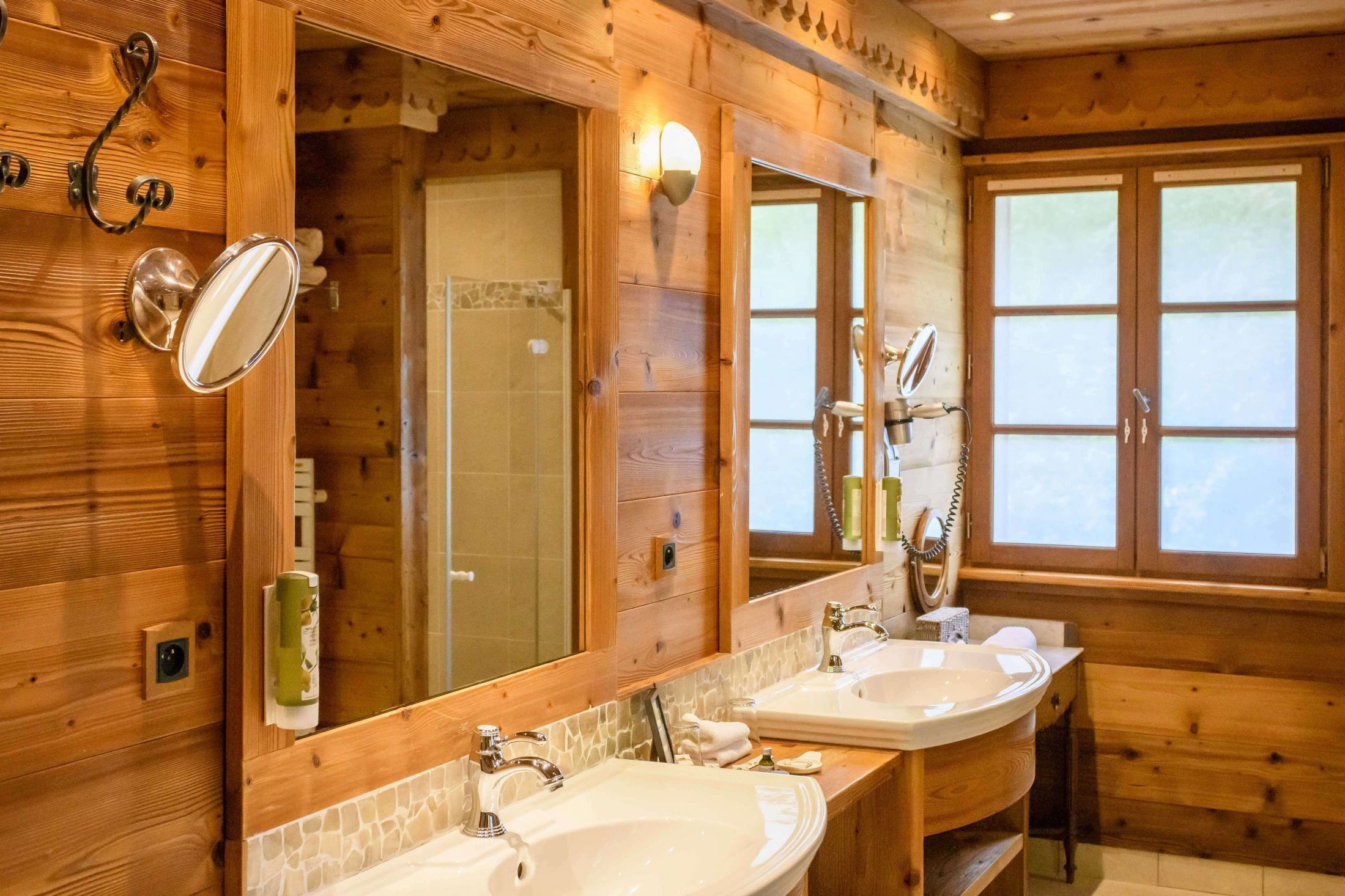 Suite de 110m² à l’esprit chalet avec poutres apparentes, salon, dressing, grande terrasse et salle de bains avec baignoire et douche.
