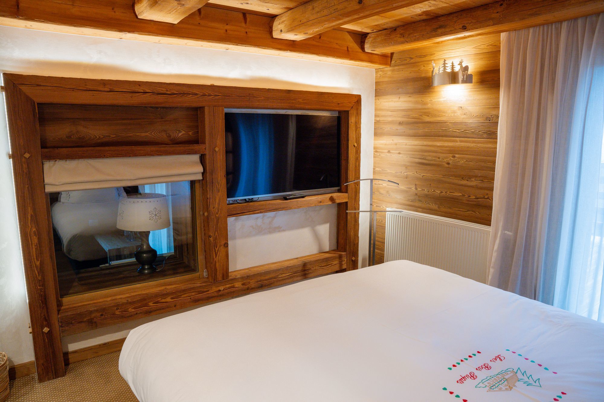 Suite Junior de l’hôtel Les Bas Rupts avec chambre, salon séparé, salle de bains moderne et terrasse offrant une vue sur la nature.