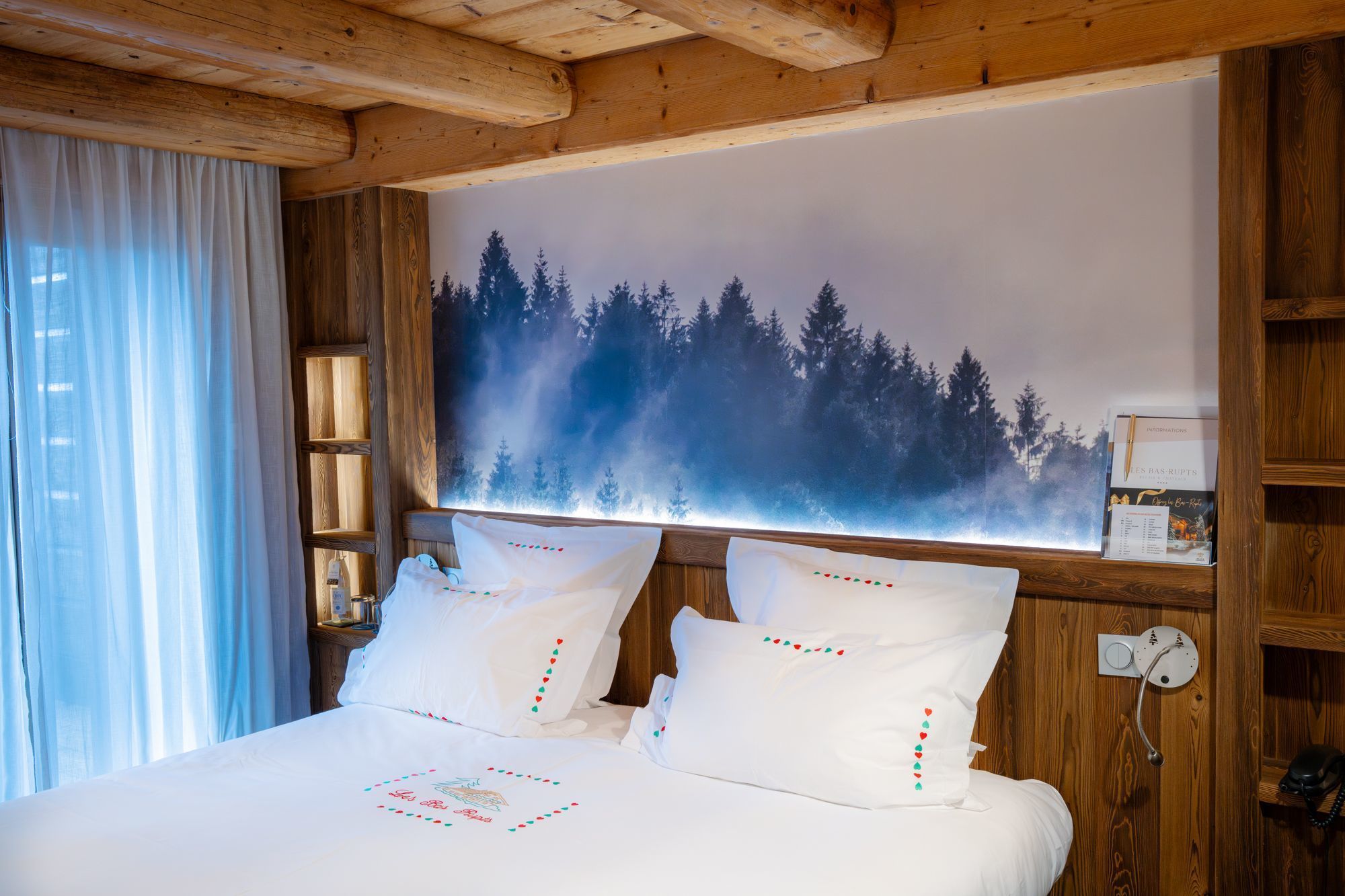Suite Junior de l’hôtel Les Bas Rupts avec chambre, salon séparé, salle de bains moderne et terrasse offrant une vue sur la nature.