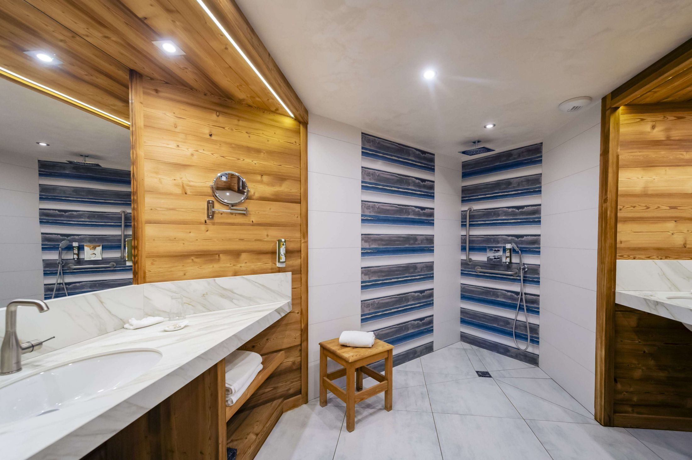Suite Junior de l’hôtel Les Bas Rupts avec chambre, salon séparé, salle de bains moderne et terrasse offrant une vue sur la nature.