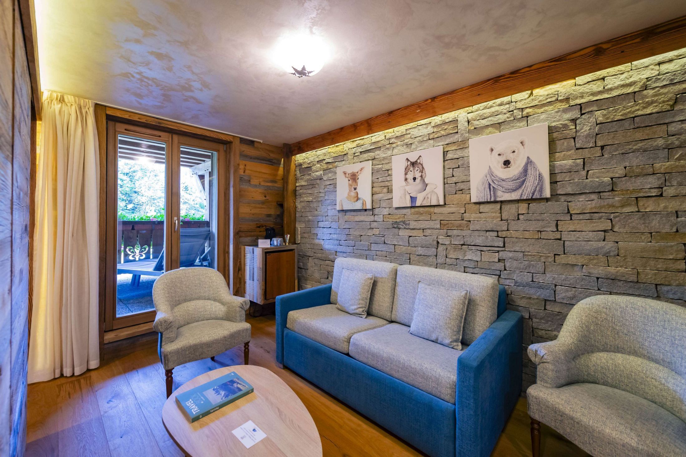 Suite Junior de l’hôtel Les Bas Rupts avec chambre, salon séparé, salle de bains moderne et terrasse offrant une vue sur la nature.