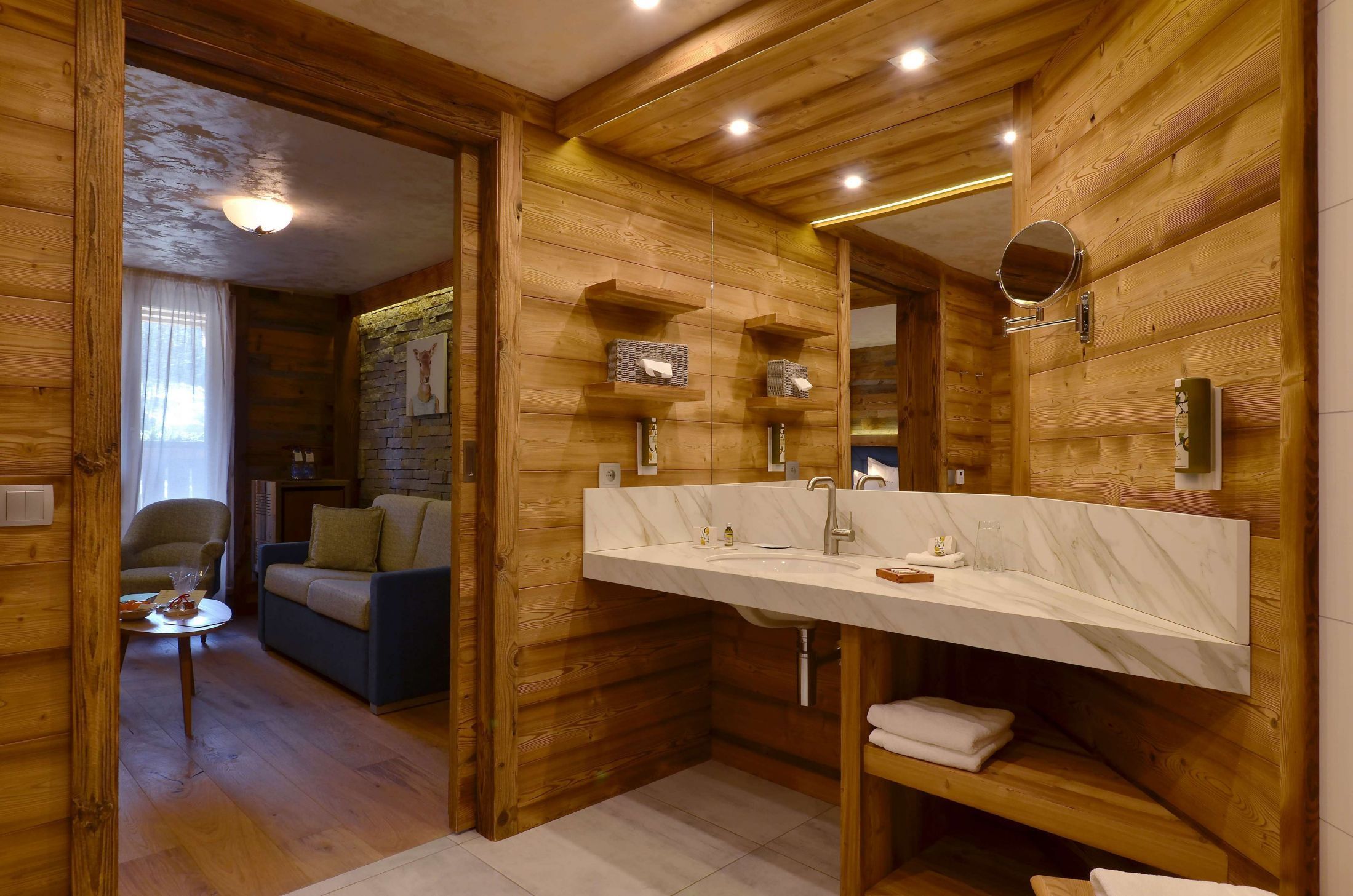 Suite Junior de l’hôtel Les Bas Rupts avec chambre, salon séparé, salle de bains moderne et terrasse offrant une vue sur la nature.