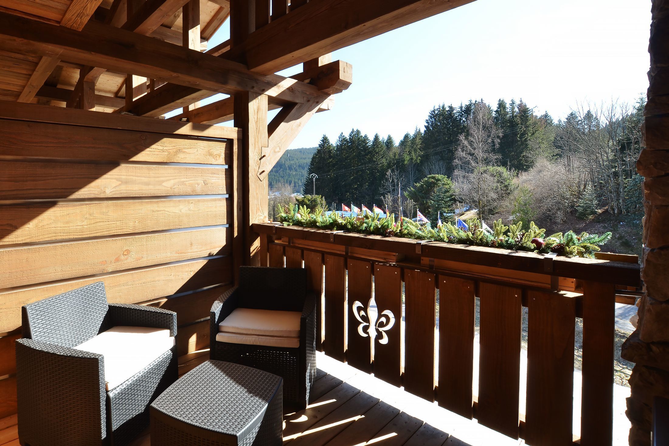 Suite Junior de l’hôtel Les Bas Rupts avec chambre, salon séparé, salle de bains moderne et terrasse offrant une vue sur la nature.