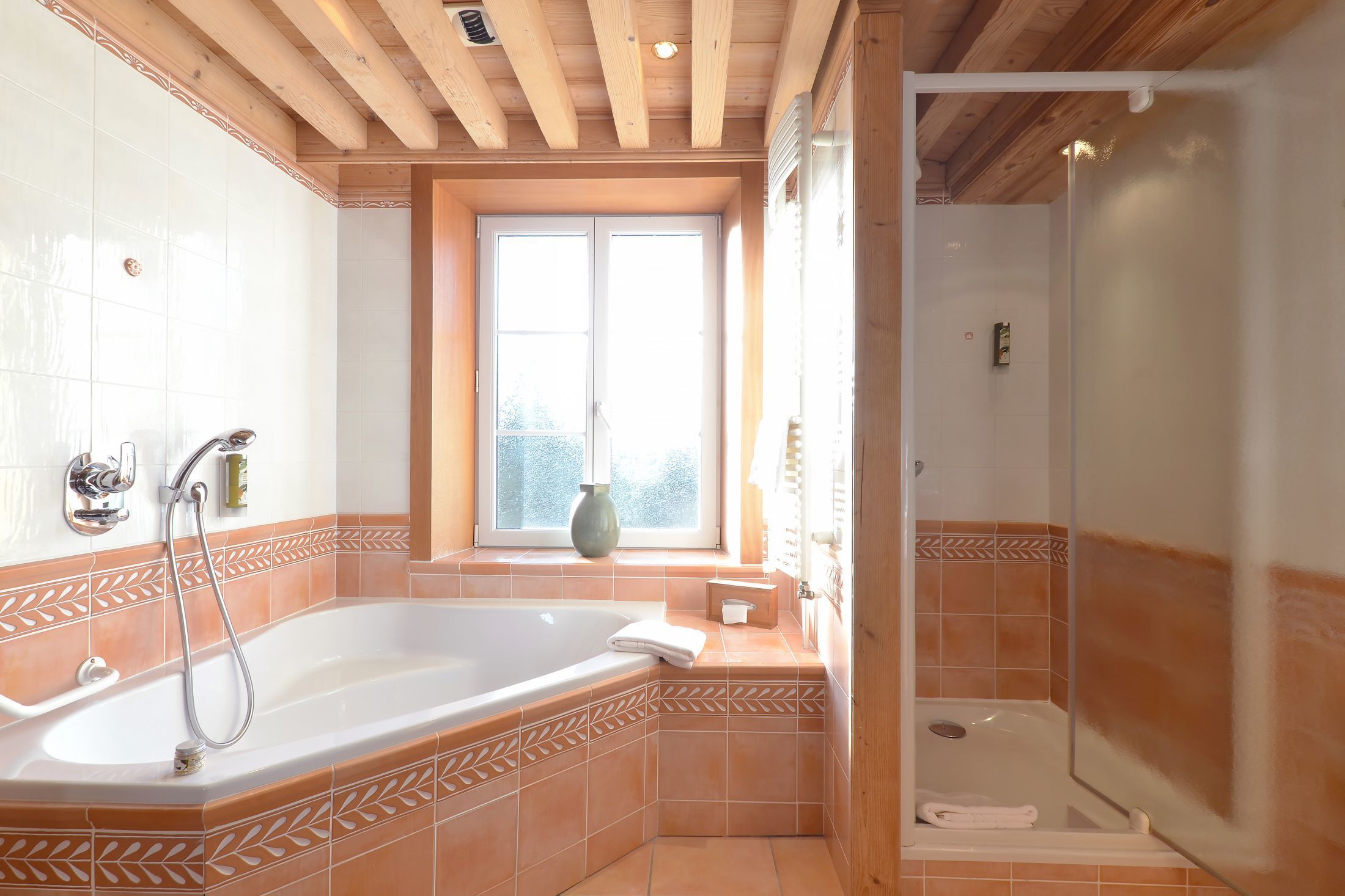 Suite Junior de l’hôtel Les Bas Rupts avec chambre, salon séparé, salle de bains moderne et terrasse offrant une vue sur la nature.