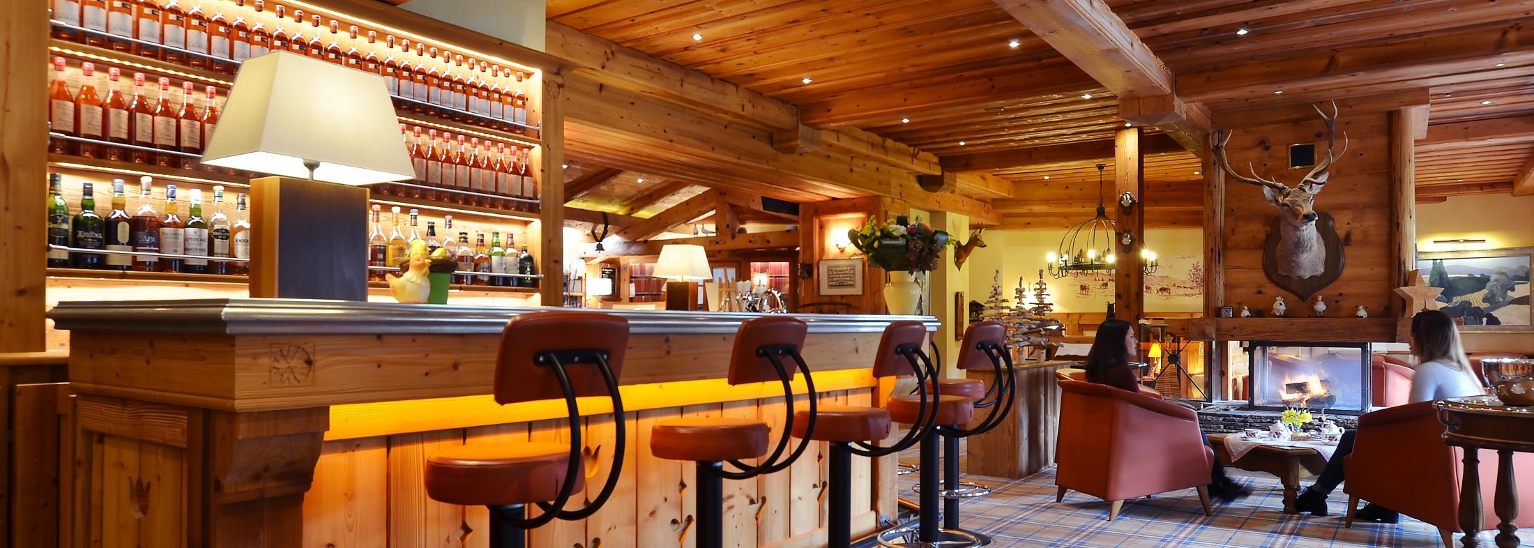 Lounge bar at Les Bas Rupts hotel in Gérardmer, Vosges, featuring fireplace, armchairs and cosy mountain atmosphere.