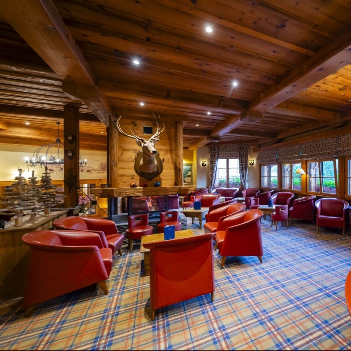 Cosy lounge armchairs and Les Bas Rupts bar menu in a bright setting in Gérardmer.